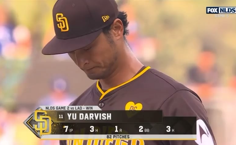 Avant de lancer le premier lancer du cinquième match de la NLDS hier soir, Yu Darvish prend un moment pour saluer le regretté propriétaire des Padres, Peter Seidler, en touchant l'écusson commémoratif sur la poitrine de son maillot.